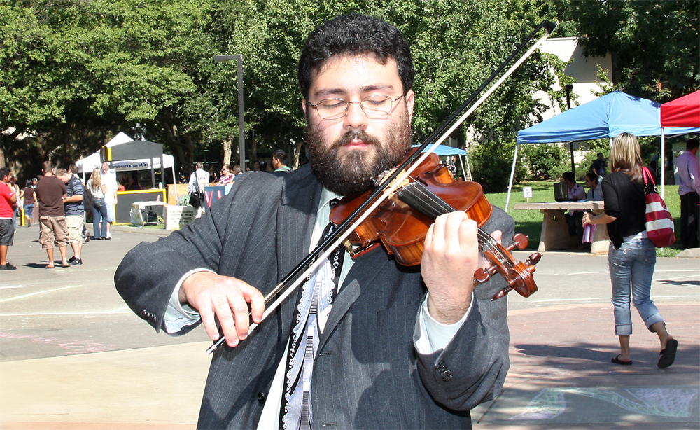 Musician playing violin on the library quad